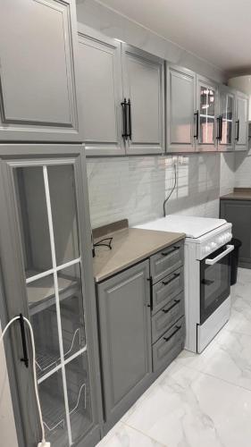 Una cocina con gabinetes blancos y encimera. en شقق الربيع, en Al Bahah
