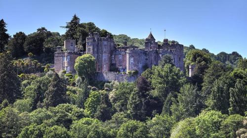 a castle on top of a hill with trees at Foxes Hotel in Minehead