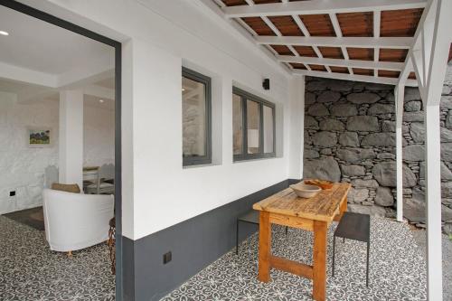 a room with a table and a stone wall at The Village Loft in Caniço