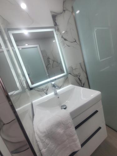 a white bathroom with a sink and a mirror at Juli's apartment in Livadhja