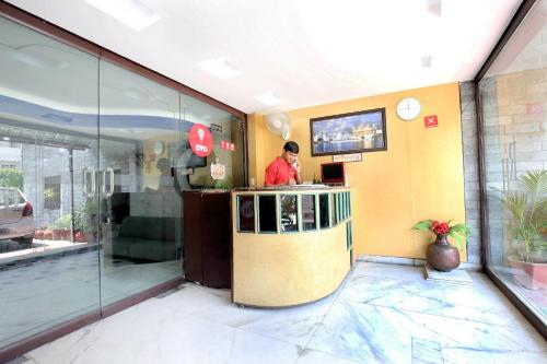 a man standing at a counter in a restaurant at Hotel O Rajmahal in Jalandhar