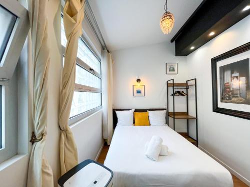 - 2 lits dans une petite chambre avec 2 fenêtres dans l'établissement 115 - Urban Vuitton Saint Denis, à Paris