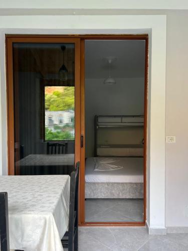 a bedroom with a door open to a bedroom with two beds at Leone Guesthouses in Borsh