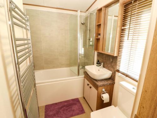 a bathroom with a shower sink and a toilet at 22 Yealand in Carnforth