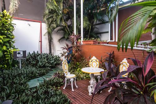 a patio with two chairs and a table and plants at Amuarama Hotel in Fortaleza