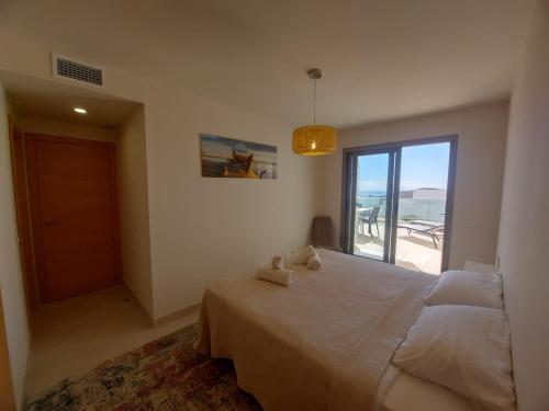 Un dormitorio con una cama y una puerta corrediza de vidrio. en Hermoso apartamento en Pulpi con jardín compartido y vistas al mar - ES-376-25, en Pulpí