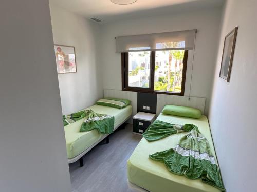 a room with two beds and a window at Apartamento acogedor a 200m de la playa con jardín comunitario - ES-376-10 in Pulpí