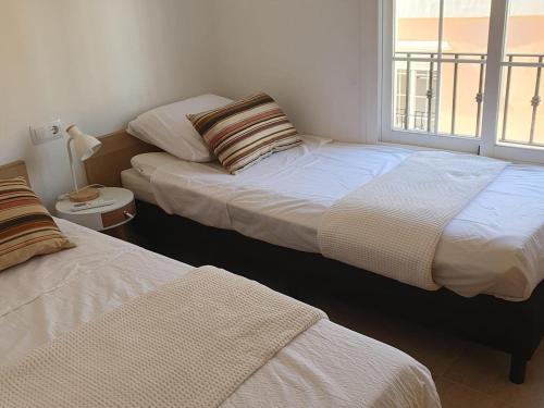 ein Schlafzimmer mit zwei Betten und einem Fenster in der Unterkunft Casa acogedora cerca de la playa en San Juan de los Terreros - ES-376-9 in Pulpí