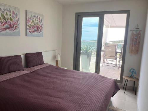 a bedroom with a purple bed and a balcony at Cómodo apartamento con WiFi y estacionamiento en Pulpí, cerca de la playa - ES-376-14 in Pulpí