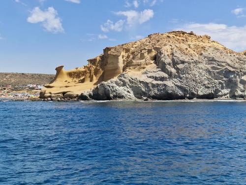 a rock formation next to the water with a beach at Cómodo apartamento con WiFi y estacionamiento en Pulpí, cerca de la playa - ES-376-14 in Pulpí