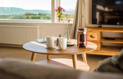 a coffee table with two coffee cups on top of it at Creag Dubh in Camastianavaig