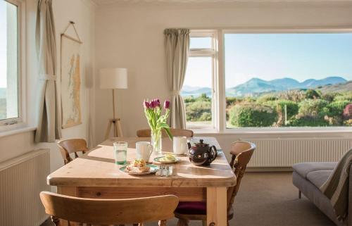 a living room with a table with a vase of flowers on it at Creag Dubh in Camastianavaig
