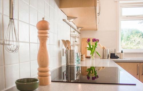 a kitchen with a counter with a vase of flowers at Creag Dubh in Camastianavaig