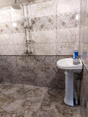 ein Badezimmer mit Waschbecken und Dusche in der Unterkunft Sulut Guest House in İsmayıllı