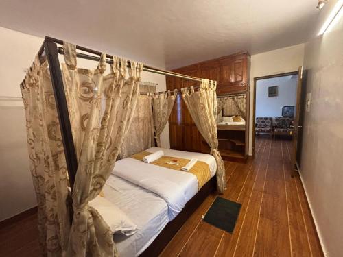 una camera da letto con un letto a baldacchino di PSR Rooms and Cottages a Ooty