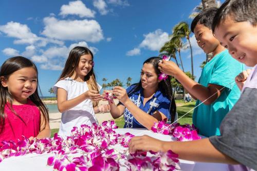 a group of people standing around a table with flowers at Marriott's Ko Olina Beach Club in Kapolei