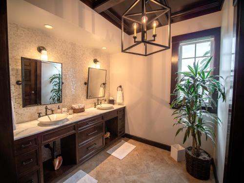 Un baño con dos lavabos y una planta en maceta. en Santa Barbara Beach Club, en Santa Bárbara