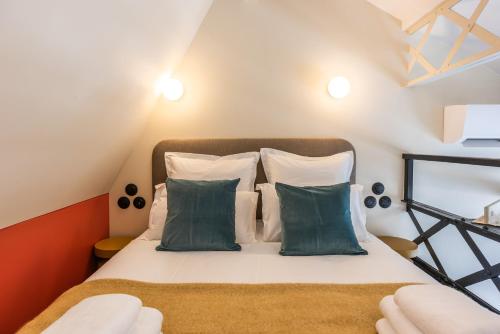 a bedroom with a bed with green and white pillows at Maison Delage in Courbevoie