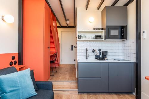 a living room with a couch and a kitchen at Maison Delage in Courbevoie