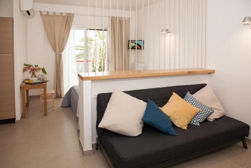 - un salon avec un canapé noir et des oreillers dans l'établissement SulMare Alba Adriatica, à Alba Adriatica