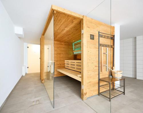 a glass shower in a room with a wooden wall at Northside I - Evergreen in Cuxhaven