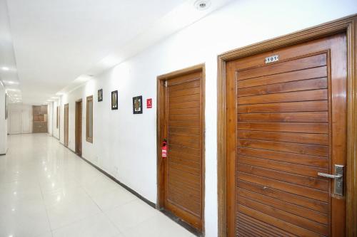 a hallway with a wooden door in a building at Super Hotel O Queensland in Amritsar