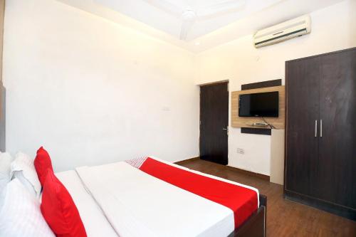 a bedroom with a bed and a television in it at Super Hotel O Queensland in Amritsar