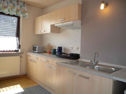a kitchen with white cabinets and a sink and a window at Apartment in Bergen auf Rügen 2835 in Bergen auf Rügen