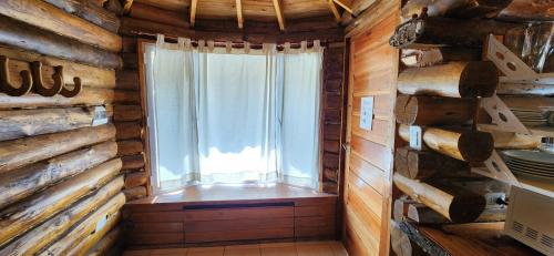 a room with a window in a log cabin at Cabin by the Mendoza River in Potrerillos