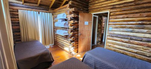 a log cabin room with a bed and a window at Cabin by the Mendoza River in Potrerillos