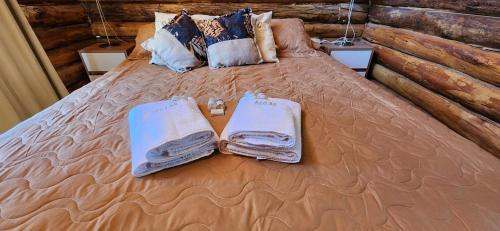 a bed with towels and pillows on it at Cabin by the Mendoza River in Potrerillos
