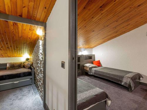 deux lits dans une chambre avec plafonds en bois dans l'établissement Appartement spacieux 4 pièces, skis aux pieds, proche remontées et commerces à Valmorel - FR-1-356-231, à Valmorel