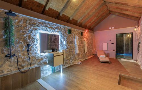 a bathroom with a shower and a stone wall at Villa Marina Neretva by Villas Guide in Metković