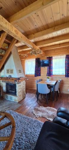 a living room with a table and a fireplace at Babiogórskie Domki in Lipnica Wielka
