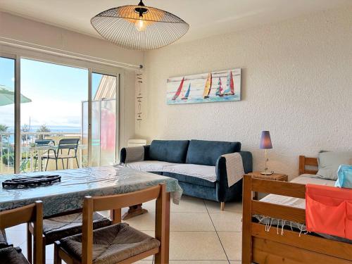 un salon avec un canapé et une table dans l'établissement Appartement cosy 2 pièces avec parking - Le Lavandou - FR-1-251-381, au Lavandou