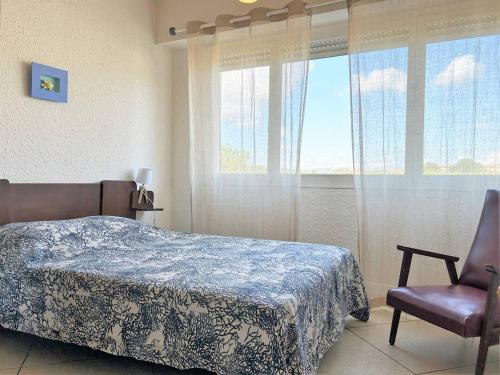 une chambre avec un lit, une chaise et une fenêtre dans l'établissement Appartement cosy 2 pièces avec parking - Le Lavandou - FR-1-251-381, au Lavandou