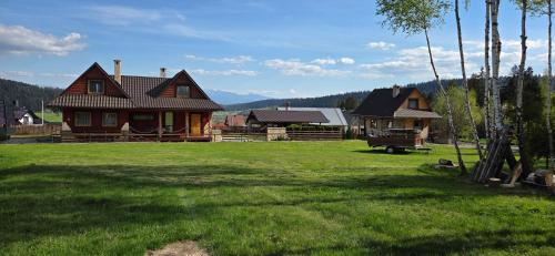 a house in a field with a green yard at Babiogórskie Domki in Lipnica Wielka