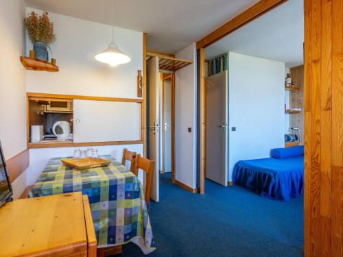 Cette chambre comprend une table et un lit. dans l'établissement Studio au centre, 4 pers, animaux admis, balcon - FR-1-353-71, à La Plagne