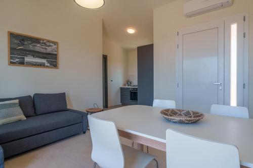 a living room with a table and a couch at Il Sughereto In Vigna in Aglientu