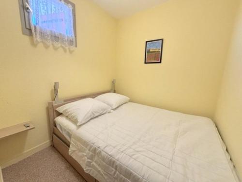 Cette petite chambre comprend un lit avec des draps blancs. dans l'établissement Agréable appartement vue sur la mer pour deux personnes 4PALMB514, au Barcarès