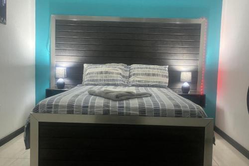 a bedroom with a large bed with a black headboard at Beautiful 3-Bed House in Saint Catherine Portmore in Central Village