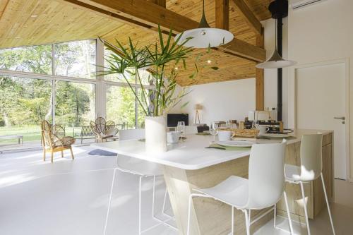 a kitchen with a large white table and chairs at La Maison Boisée - Welkeys in Orx