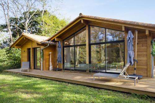 a log cabin with a deck and a lawn at La Maison Boisée - Welkeys in Orx
