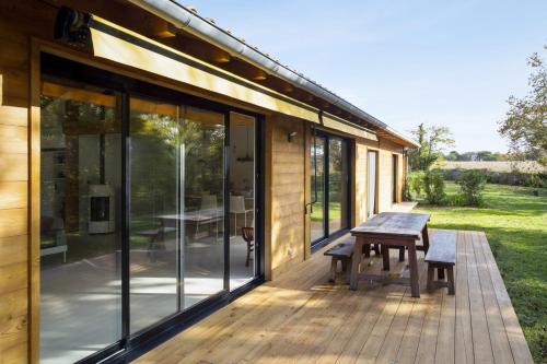 a wooden deck with a picnic table on a house at La Maison Boisée - Welkeys in Orx