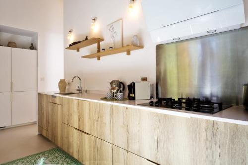 a kitchen with wooden cabinets and a stove top oven at La Maison Boisée - Welkeys in Orx