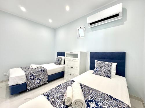 a bedroom with two beds and a dresser at Almancil Typical House by Homing in Almancil