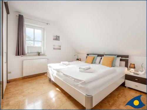a large white bed in a room with a window at Fraeulein Loddin Whg_ Hugo in Kolpinsee
