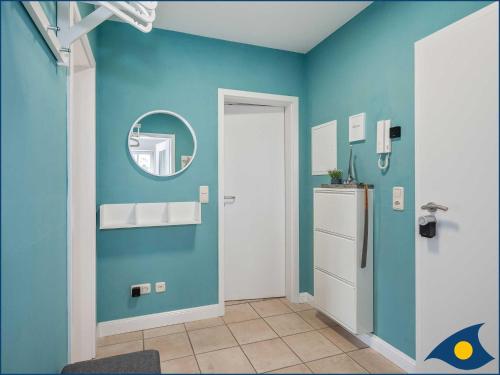 a room with a blue wall with a refrigerator at Fraeulein Loddin Whg_ Hugo in Kolpinsee