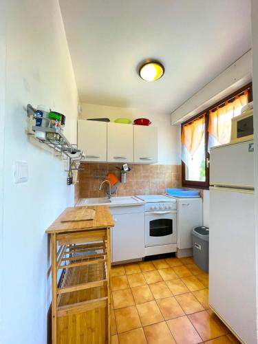 une cuisine avec des armoires blanches et un réfrigérateur blanc dans l'établissement Nice Studio With Balcony Near The Beach, à Fréjus