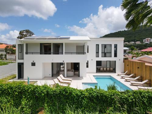 ein großes weißes Haus mit Swimmingpool in der Unterkunft Villa Raphael in Sainte-Luce